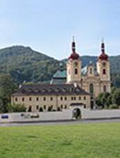 Pohled od severu na kostela, nalevo od n� se nach�z� objekt kl�tera. Jeho p��zem� je ov�em skryto za kl�tern� zd�. V&nbsp;pozad� vystupuj� svahy Jizersk�ch hor.